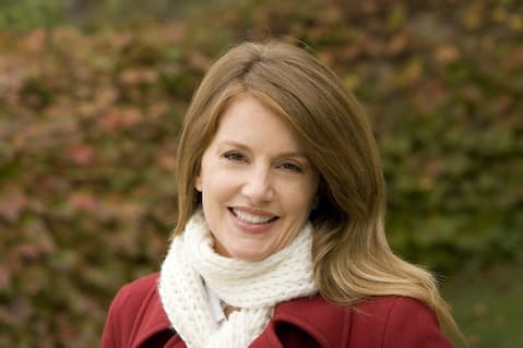 Beautiful woman outdoors in red coat with white scarf